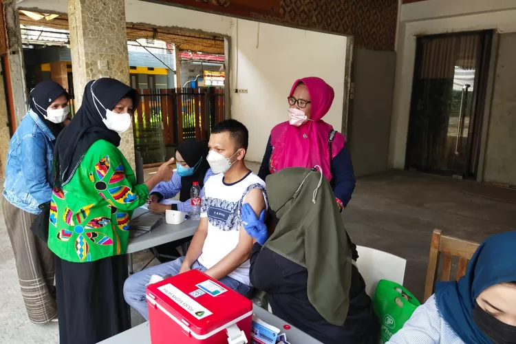 Salah satu warga Kali Baru saat vaksin di RM Rumpikal. (FOTO: Humas Polres Metro Bekasi Kota)