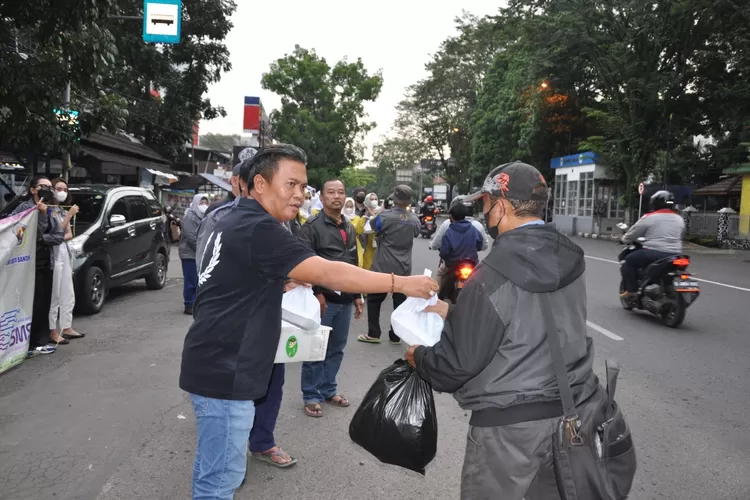 ketua PWI Kota Bandung H Hardiyansyah membagikan ratusan tajil gratis kepada pengguna jalan, di sekiran jalan ahmad yani, Selasa (26/4)