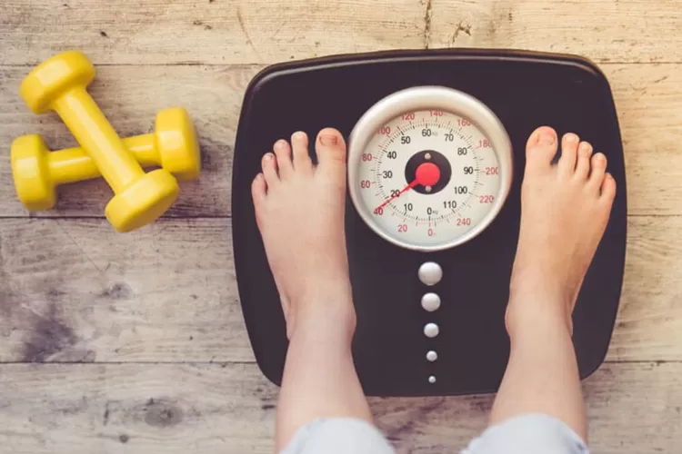 Ilustrasi menimbang dalam tips turunkan berat badan pasca lebaran