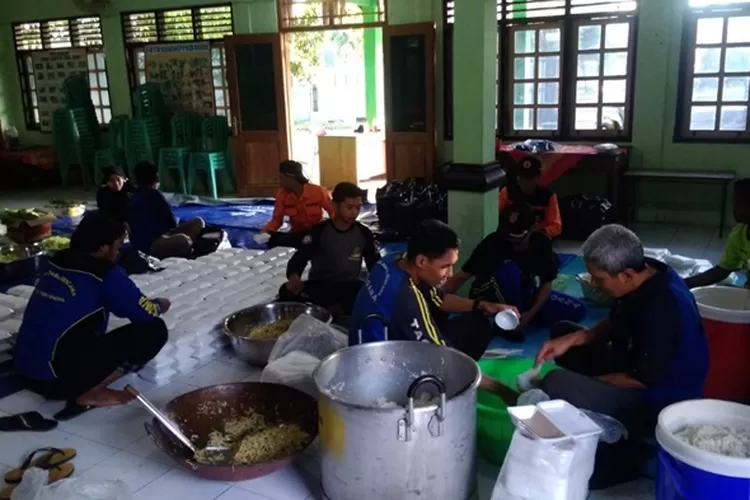 Petugas memberikan makanan kepada warga yang  terdampak banjir rob di Kelurahan Karangsari dan Desa Mororejo dari dapur umum yang didirikan di dua lokasi tersebut.  (edi prayitno/ kontributor Kendal)