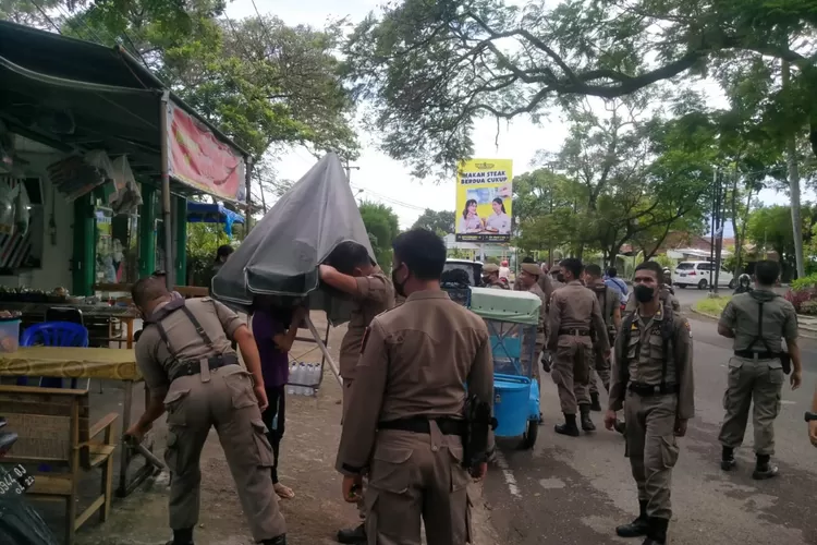 Petugas Satpol PP saat menertibkan lapak pedagang yang berada di trotoar pada beberapa ruas jalan di Kota Padang