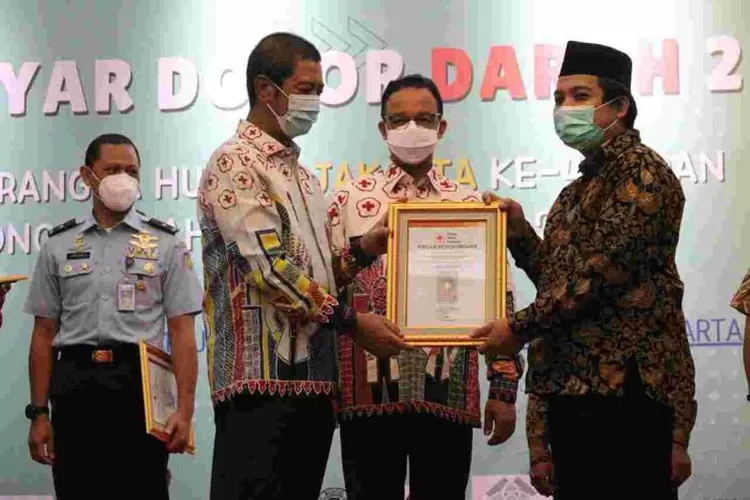 Ketua PMI Provinsi DKI Jakarta Rustam Effendi (kiri) menyerahkan penghargaan kepada pendonor yang sudah 150 kali.donor darah disaksikan Gubernur FKI Anies Baswedan, Selasa (14%6/2022).