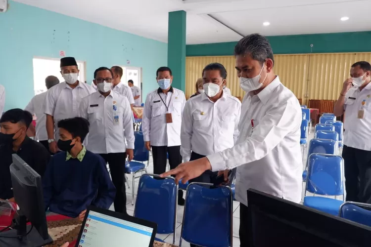 Ilustrasi foto, Pj Gubernur Banten Al Muktabar (tengah) didampingi Kepala Dindikbud Provinsi Banten Tabrani memantau pelaksanaan hari pertama PPDB di SMAN 1 Kota Serang. (topmedia)