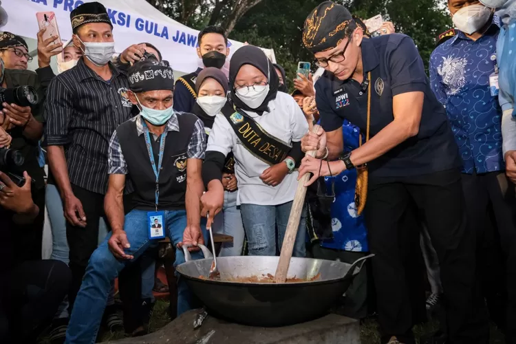Menparekraf Sandiaga Uno tengah mencoba membuat gula kelapa saat kunjungannya ke Desa Wisata Semen Blitar yang masuk ke dalam 50 Besar Anugerah Desa Wisata Indonesia (ADWI) 2022, Jawa Timur, Rabu (29/6/2022).