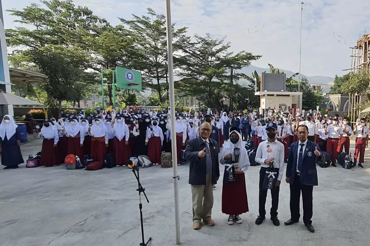 Ketua Yayasan Prima Cendekia islami Prof. Dadan Wildan dan Kepala Sekola SMP PCI Beny Saputro (kanan) memberikan seuntai bunga kepada perwakilan murid baru - Foto: Prima Cendekia Islami 