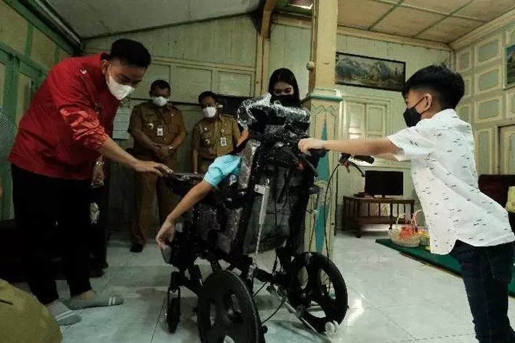 Jan Ethes mendorong kursi roda anak berkebutuhan khusus bantuan dari Mensos  (Endang Kusumastuti)