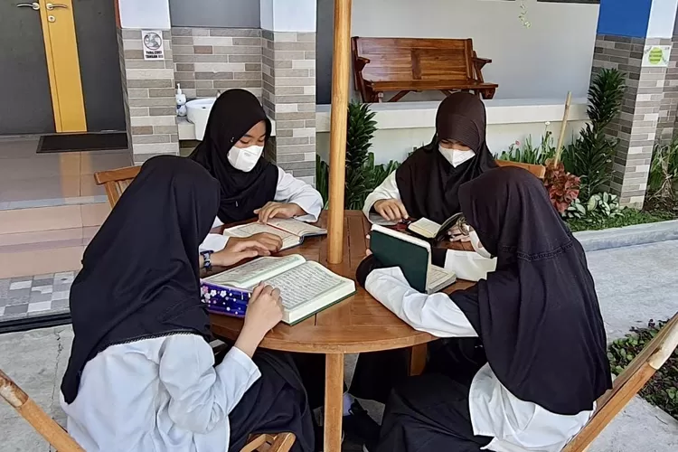 Siswi SMP Prima Cendekia Islami ketika membaca Al Quran di halaman sekolah 