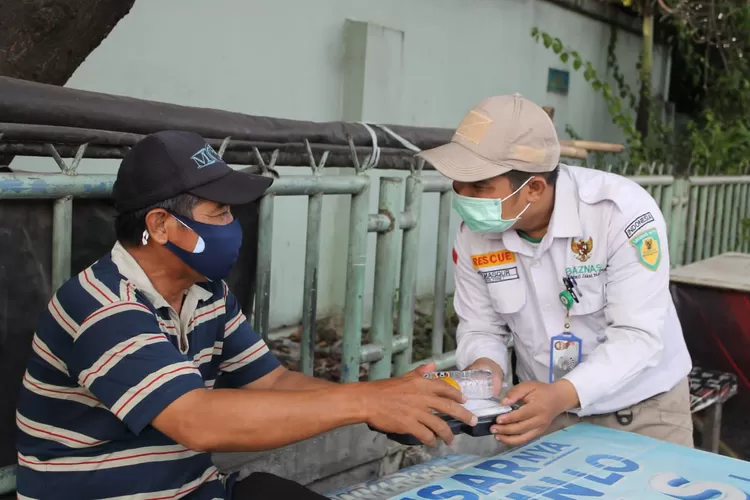 Relawan Baznas menyerahkan paket makanan siap saji kepada pekerja rentan  di Tangerang, Rabu (27/7/2022).