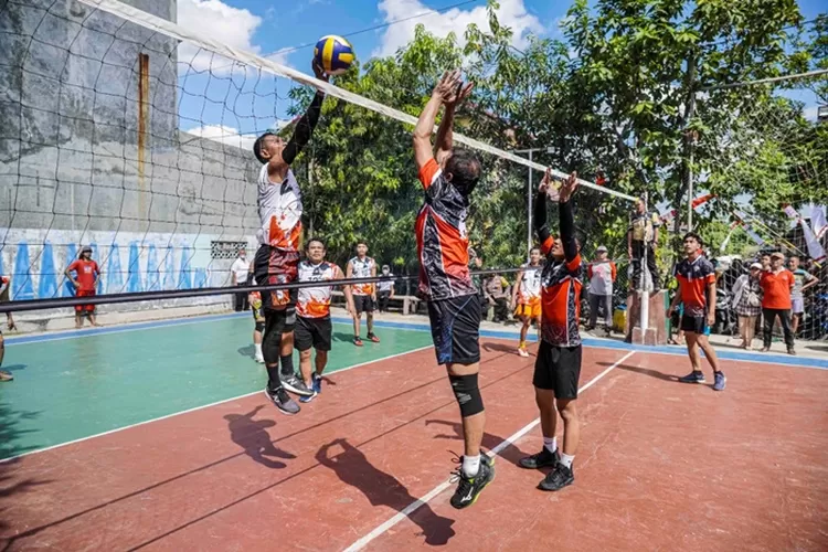 Pemain RW 14, Harsoyo (merah, kiri) dan Muhammad Rifqi berusaha melakukan bloking saat lawan RW 7. RW 14 menjuarai lomba voli Kelurahan Plamongan Sari. (Ayosemarang.com/ Audrian Firhannusa)