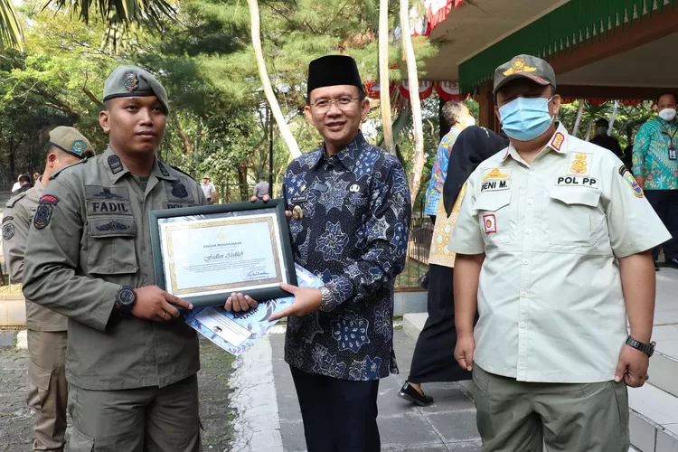 Pj Bupati Bekasi Dani Ramdan memberikan penghargaan kepada anggota Satpol PP. (FOTO: Dok. Pemkot Bekasi).