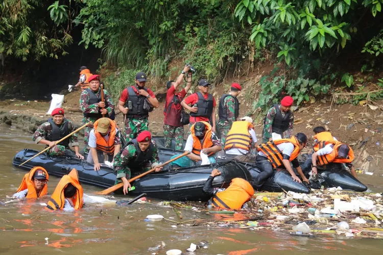 Prajurit Kpassus dan warga membersihkan Sungai Ciliwung. 