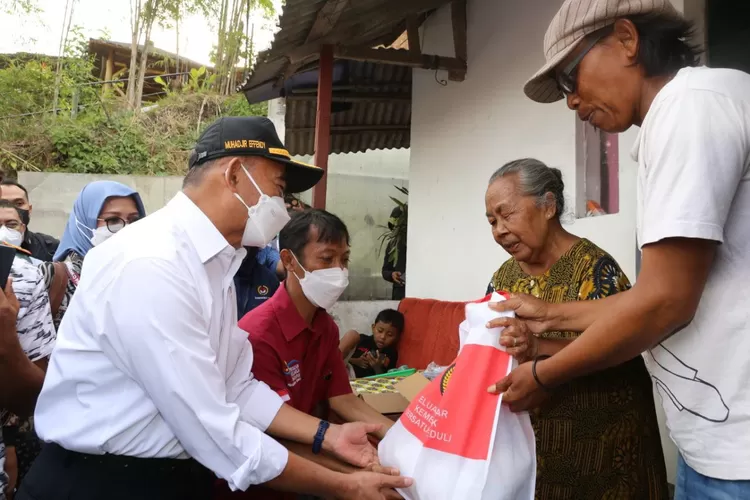 Menko PMK Muhadjir Effendy (kiri) memberi bantuan, pada satu keluarga miskin ekstrem di Malang. 