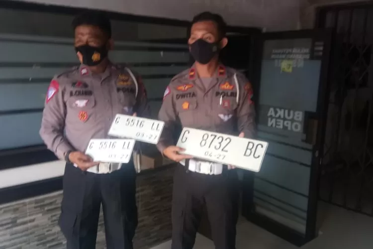 Kanit Regident Satlantas Polres Batang, Ipda Dwita Pratama saat menunjukan Plat Nomor kendaraan atau Tanda Nomor Kendaraan Bermotor (TNKB) dengan warna dasar putih.  (MUSLIHUN/AYOSEMARANG.COM)