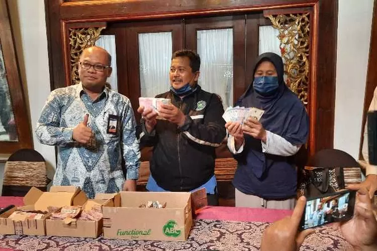 Kepala KPwBI Solo Nugroho Joko Prastowo menyerahkan uang pengganti uang yang rusak domakan rayap kepada Samin dan istrinya (Endang Kusumastuti)