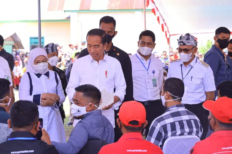 Presiden Joko Widodo (tengah) didampingi Menaker Ida Fauziyah (kiri) tinjau penyaluran BSU. 