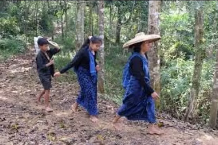 Warga Suku Baduy melintas di tepian hutan.