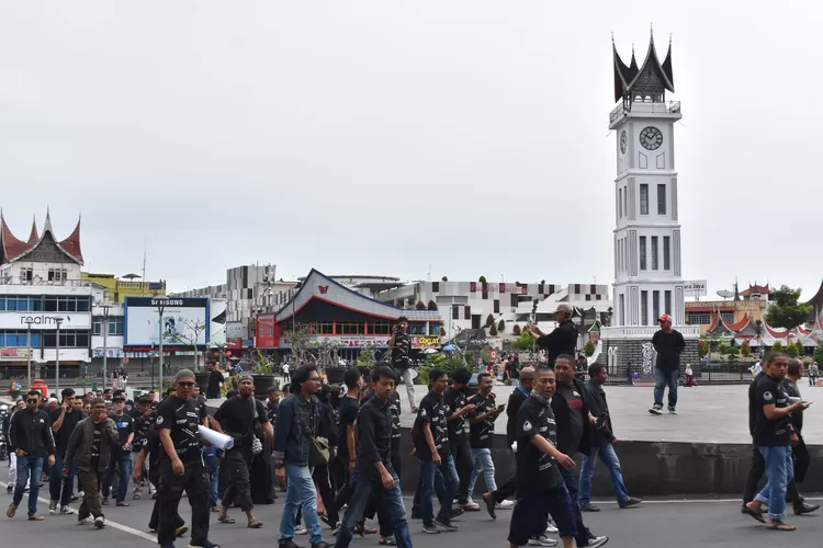 Ratusan massa dari Syarikat Pedagang dan Pemilik Toko Jalan Minangkabau melakukan long march melewati Jam Gadang menuju DPRD Kota Bukittinggi