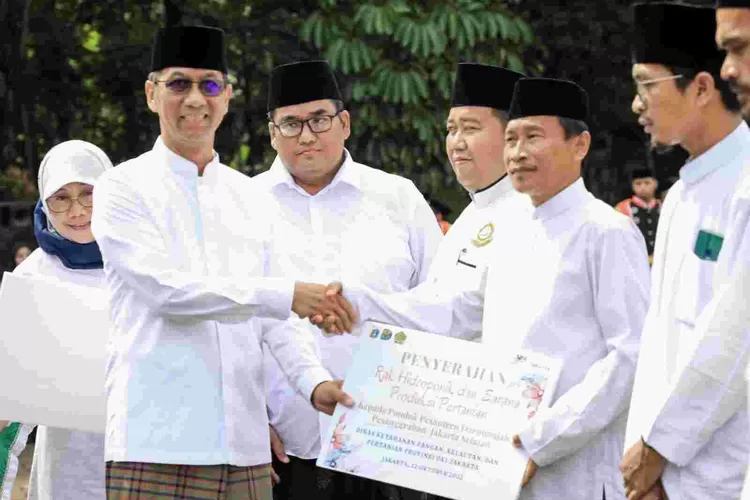 Pj Gubernur DKI Jakarta Heru Budi Hartono menyerahkan bantuan alat pertanian perkotaan kepada salah seorang pengurus pesantren Sabtu (22/10/2022)