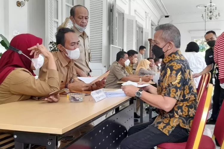 Koordinator Tim Penertiban Aset Pertamina Aditya Parma (duduk baju batik) saat menyampaikan laporan pengaduan kepada petugas posko pelayanan pengaduan di Pendopo Balai Kota DKI Jakarta, Senin (24/19/2922).
