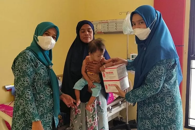 Ketua TP-PKK Luwu Utara, Ny. Rahma Nursaid Suaib, memberikan bantuan makanan tambahan kepada seorang balita, Kamis (27/10/2022), di Desa Sidomukti  (Dok. Istimewa)