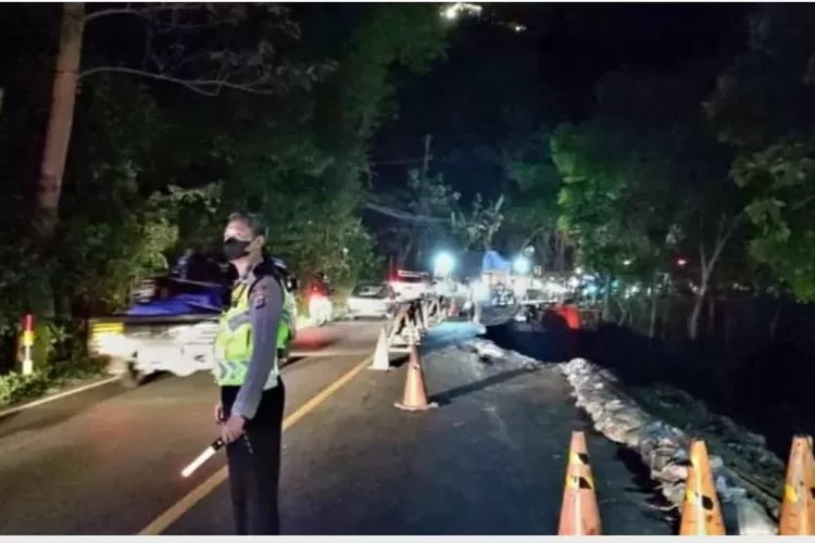 Petugas berjaga-jaga di kawasan jalan Jogja-Wonosari yang ambles. (Dokumen Polres Bantul via Suara.com)