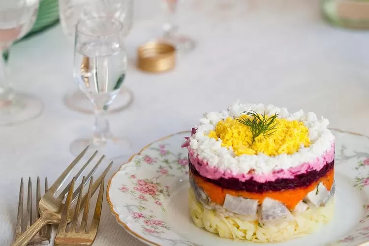 Ilustrasi shuba atau herring under a fur coat, salah satu jenis makanan Natal unik di dunia.