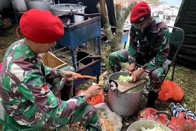 Prajurit Kopassus membantu menyiapkan makanan untuk warga korban gempa Cianjur. 