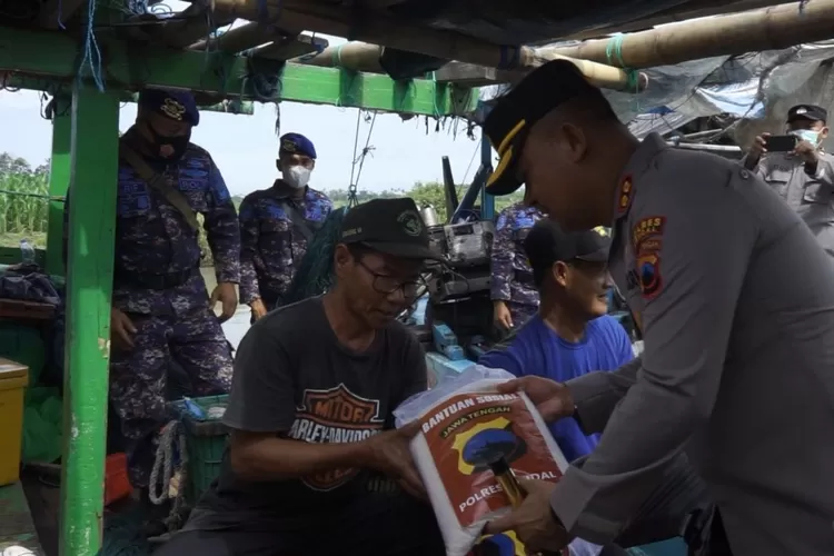 Kapolres Kendal AKBP Jamal Alam menyerahkan sembako kepada nelayan Birusari, Kendal dalam rangkaian HUT Polairud ke-72, Kamis 1 Desember 2022. (Edi Prayitno/Kontributor Kendal)