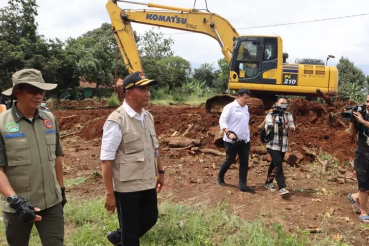 Kepala BNPB Letjen TNI Suharyanto (kemeja hijau dengan rompi) dan Menko PMK Muhadjir Effendy (kemeja putih dengan rompi) meninjau salah satu lokasi lahan relokasi bagi warga terdampak gempa di Kabupaten Cianjur, Jawa Barat pada Rabu (30/11). (Komunikasi Kebencanaan BNPB / Muhammad Arfari Dwiatmodjo)