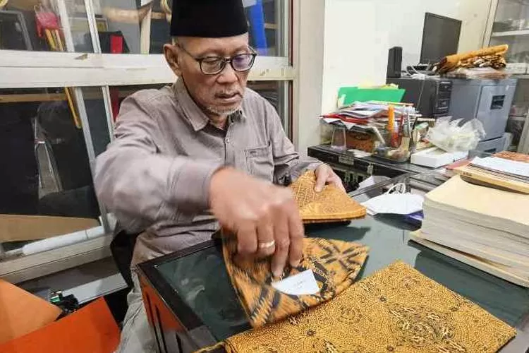 Sugiyatno dari Toko Busana Jawi Suratman memperlihatkan jarik motif batik pesanan Presiden Jokowi (Endang Kusumastuti)