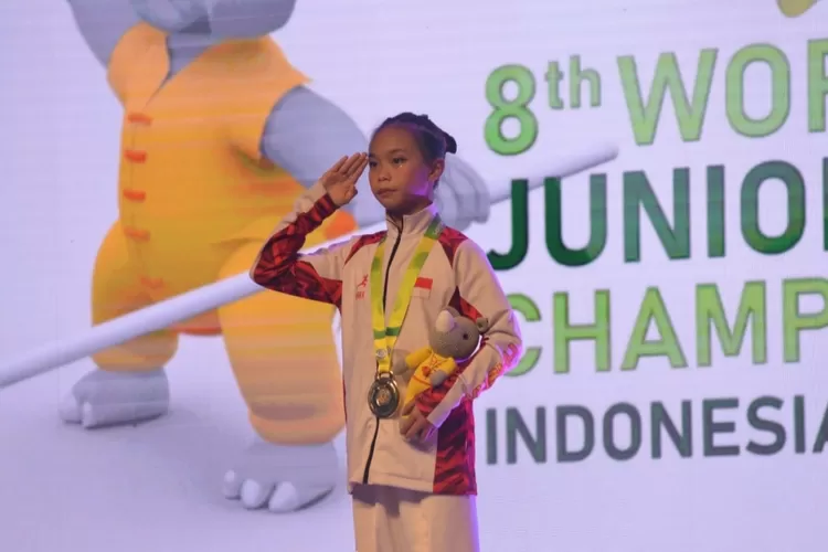 Atlet cilik wushu Indonesia Annasera Zahraa Haryoso  memberi rasa hormat saat pengibaran bendera Merah Putih dari podium juara 1 dengan merebut emas saat turun di kelompok Junior C Putri, dari nomor Changquan dengan mengantongi 9,136 poin  (AG Sofyan )