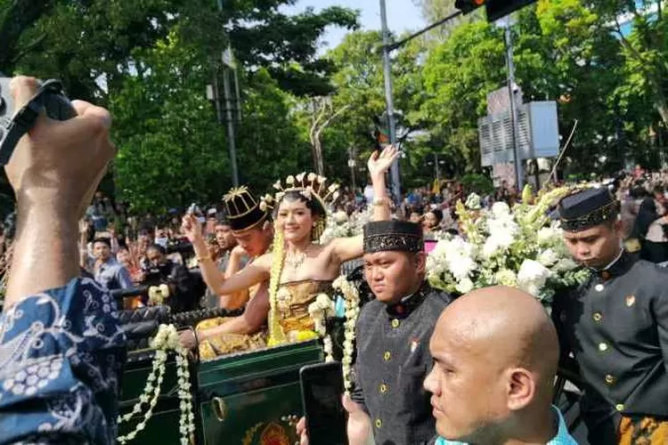 Pasangan pengantin Kaesang Pangarep dan Erina Gudono menyebar udik-udik saat kirab kereta kencana (Endang Kusumastuti)