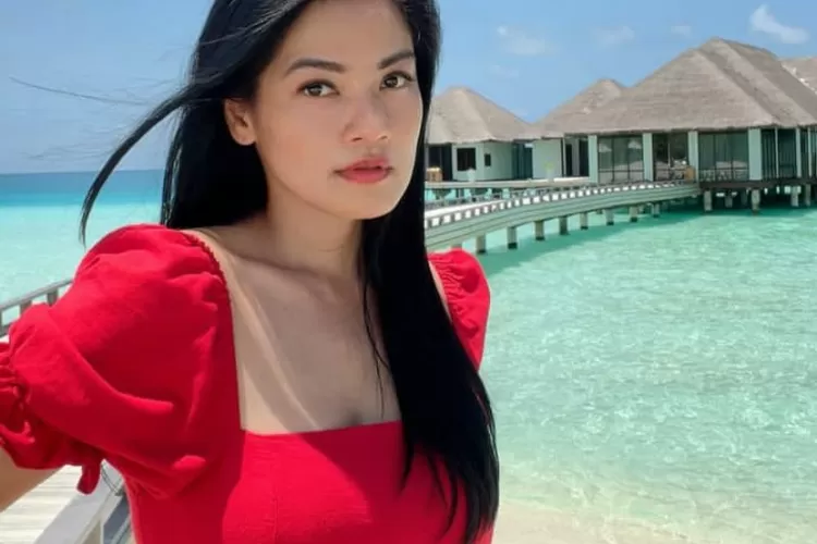 Titi Kamal berlatar belakang lautan Maldives.