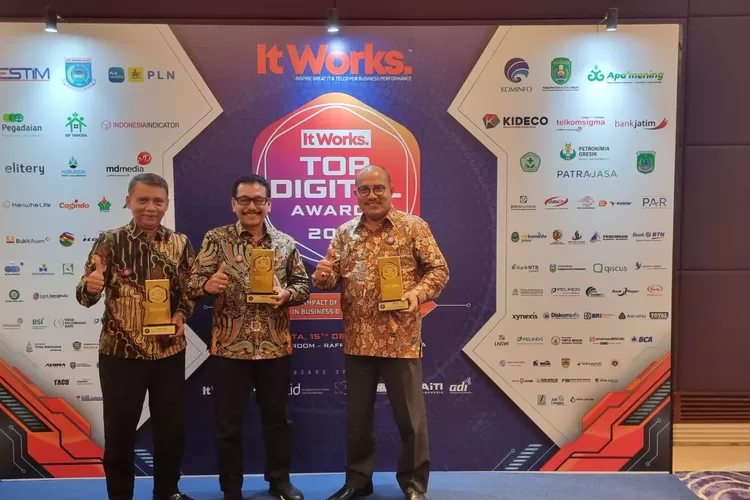 Dirut Bank Nagari Muhamad Irsyad (tengah) didampingi Direktur Keuangan Sania Putra (kanan) dan Pemimpin Divisi Sekper Idrianis (kiri) saat memegang penghargaan TOP DIGITAL Awards 2022, Kamis (15/12). IST