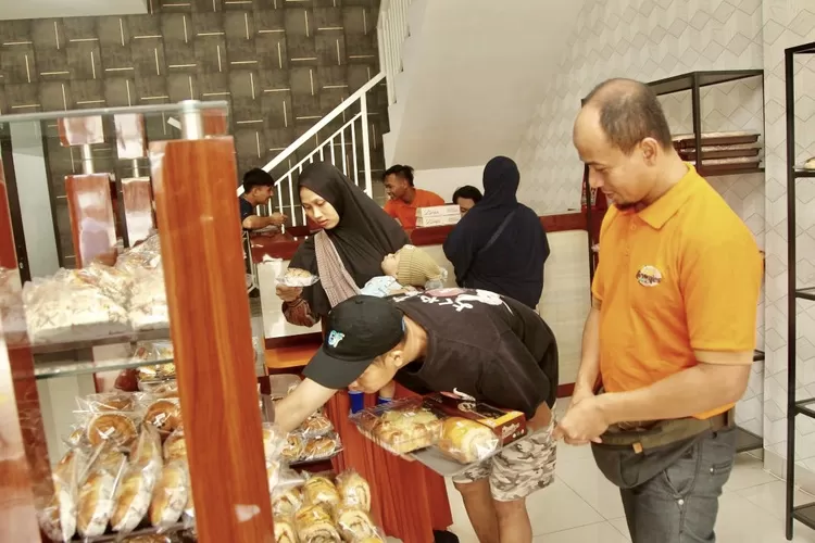 Owner Rumah Brownies H. Bubun Bunyami sedang melayani pelanggan dihari pertam pembukaan outlet Alisya Bakery - Foto: Henry Lukmanul Hakim