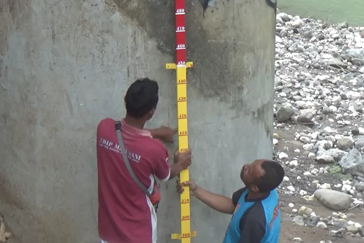 Petugas sedang mengukur jalan kawasan Wunut Sriharjo Bantul yang ambles dan rusak parah. (Istimewa)