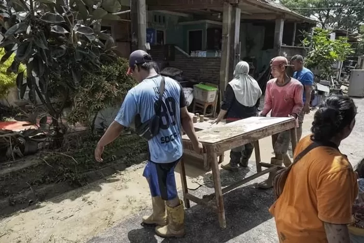 Warga Perumahan Dinar Indah sedang melakukan pembersihan pasca banjir.  (Ayosemarang.com/ Audrian Firhannusa)