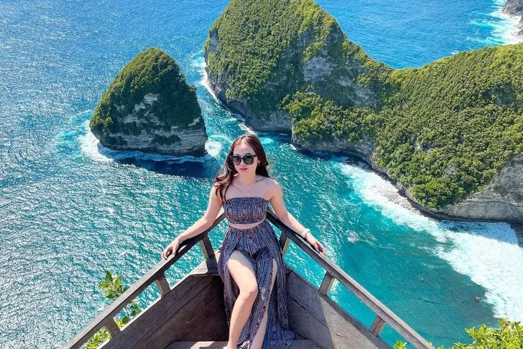 Salah satu turis berpose dengan latar belakang pantai di Nusa Penida, Bali yang menjadi salah satu tempat wisata yang membuat para turis asing betah. (Instagram @tournusapenidascenery)
