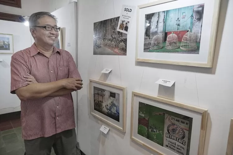 Fotografer Semarang Lim Winasdy saat melihat pamerannya untuk mempromosikan buku fotonya De Oude Stad.  (Ayosemarang.com/ Audrian Firhannusa)