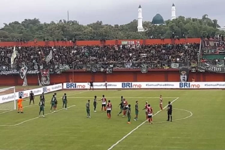 Caption: Laga Madura United melawan Persebaya Surabaya Dalam lanjutan Liga 1