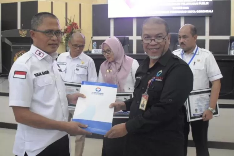 Sekda Kota Gorontalo, Ismail Madjid menerima penghargaan dari Ombudsman RI perwakilan Provinsi Gorontalo untuk tiga OPD. (Humas Pemkot Gorontalo)