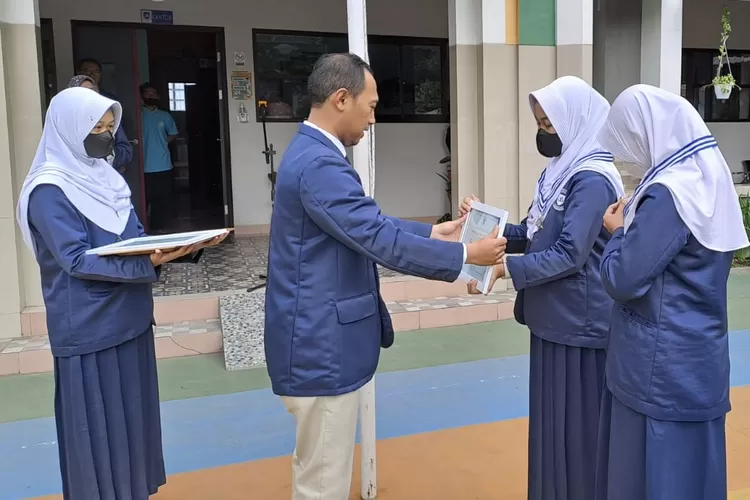 Kepala SMP Prima Cendekia Islami Beny Saputro, S.Pd., M.Pd  ketika memberikan medali Bintang Pelakjar kepada dua siswa berprestasi - Foto: Humas Prima Cendekia Islami