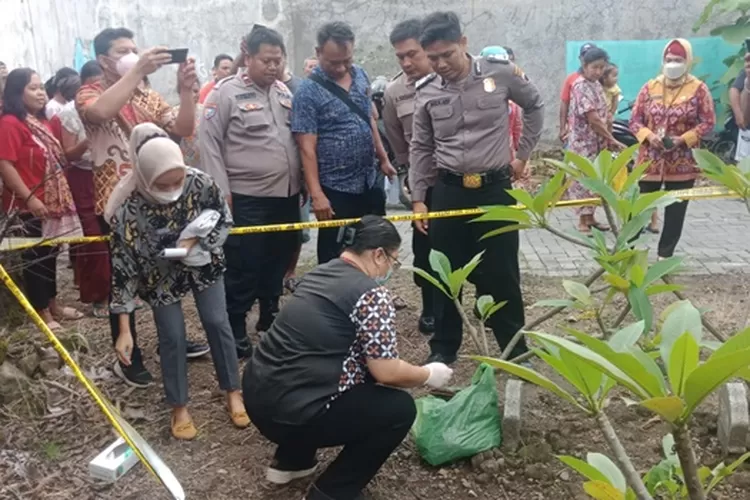 Polisi dan tim Puskesmas Genuk sedang mengevakuasi bayi sudah tak bernyawa yang dibuang di pemakaman Genuk Semarang.  (Polsek Genuk)