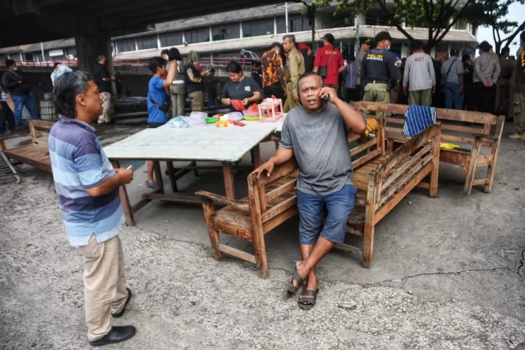 Pedagang pemilik kios di bawah flyover Pelabuhan Tanjung Emas saat duduk di perkakas dagangnya yang ditertibkan oleh Satpol PP Semarang. (Ayosemarang.com/ Audrian Firhannusa)