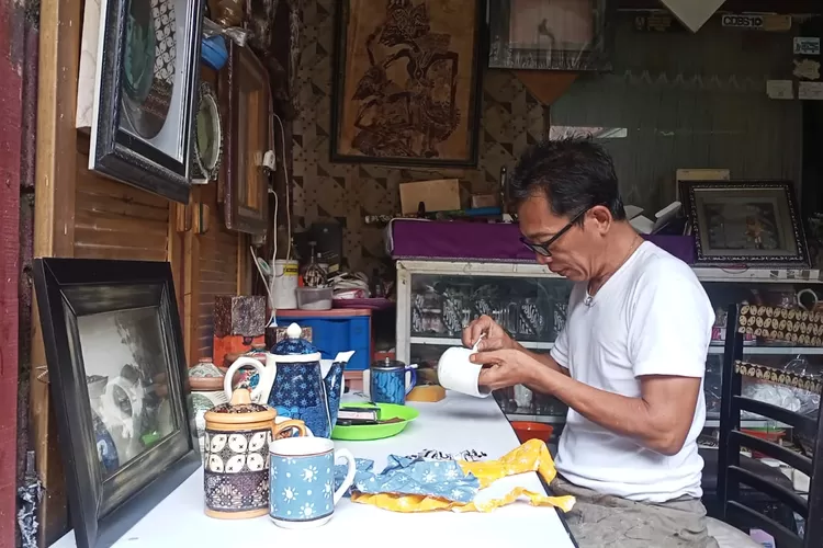 KREATIF : Suyono sedang membuat kerajinan batik rekat pada gelas yang menggunakan kain percak, di Say Galeri, Kelurahan Sukmajaya, Kota Depok, Selasa (14/1).  (ASHLEY/RADAR DEPOK)