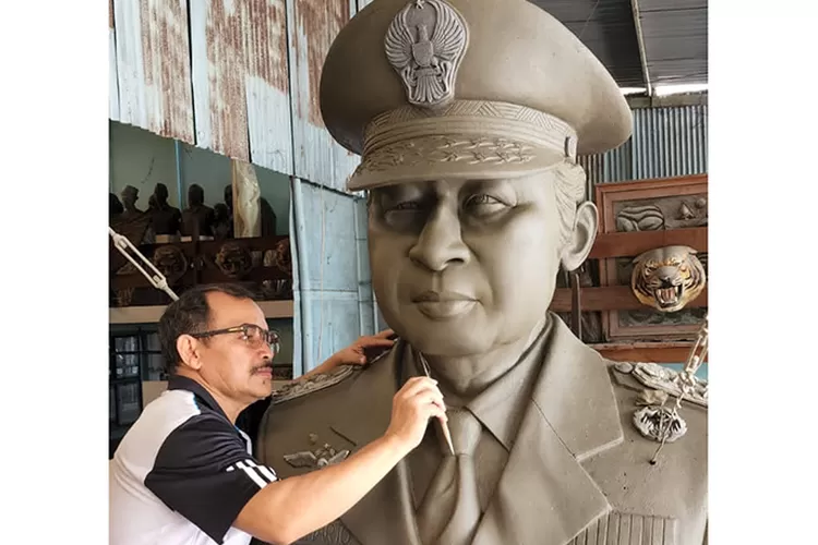 Yusman sedang menggarap proses detail patung Soeharto.  (Teguh Priyono)