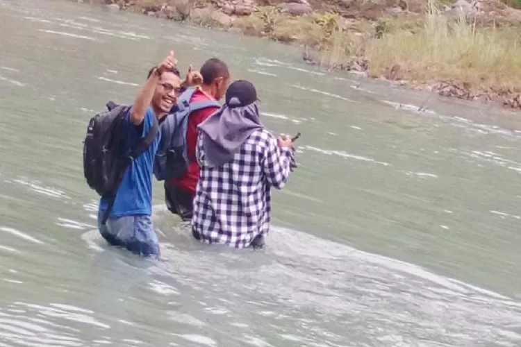 Muhamad Ibrahim bersama Pantarlih dan PPS menyebrangi sungai untuk pencoklitan di Jengok Rabu (15/2/2023)
