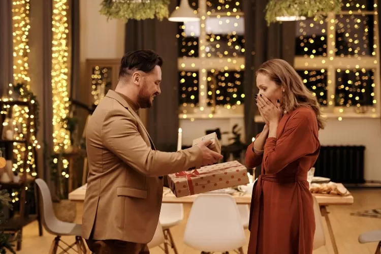 Ilustrasi pria memberikan hadiah kepada wanita sebagai bentuk bukti cinta (Pexels/Nicole Michalou)
