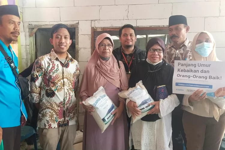 GEMBIRA : Salah seorang warga yang mendapatkan bantuan sembako dari Yayasan Kitabisa dan Pena Bakti.