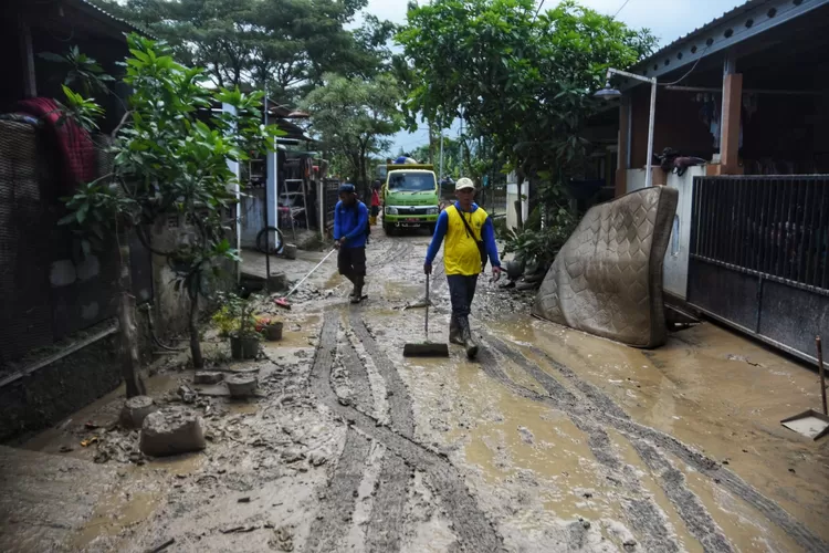 Petugas sedang membersihkan sisa banjir di Perumahan Dinar Indah Semarang. (Ayosemarang.com/ Audrian Firhannusa)